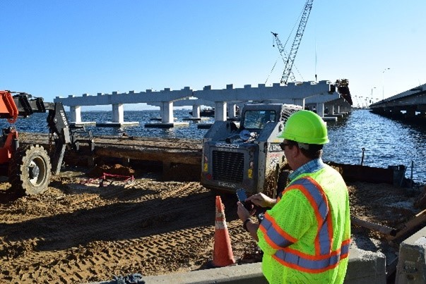 Man in safety gear at a bridge construction site.